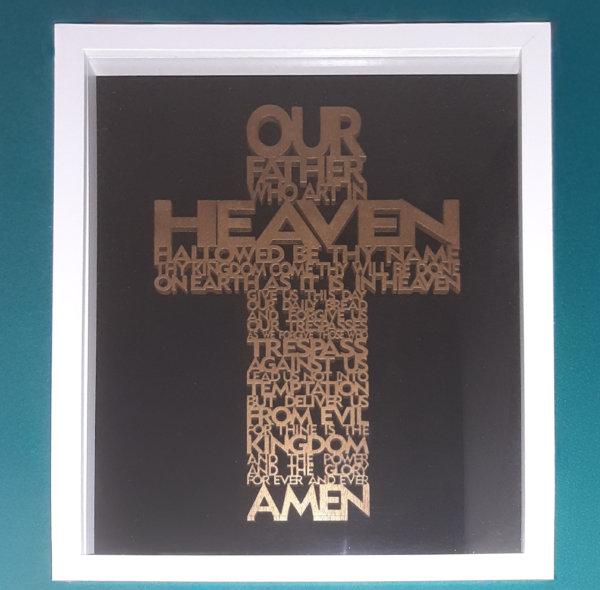 Lords prayer in the shape of a cross in a white frame and black background